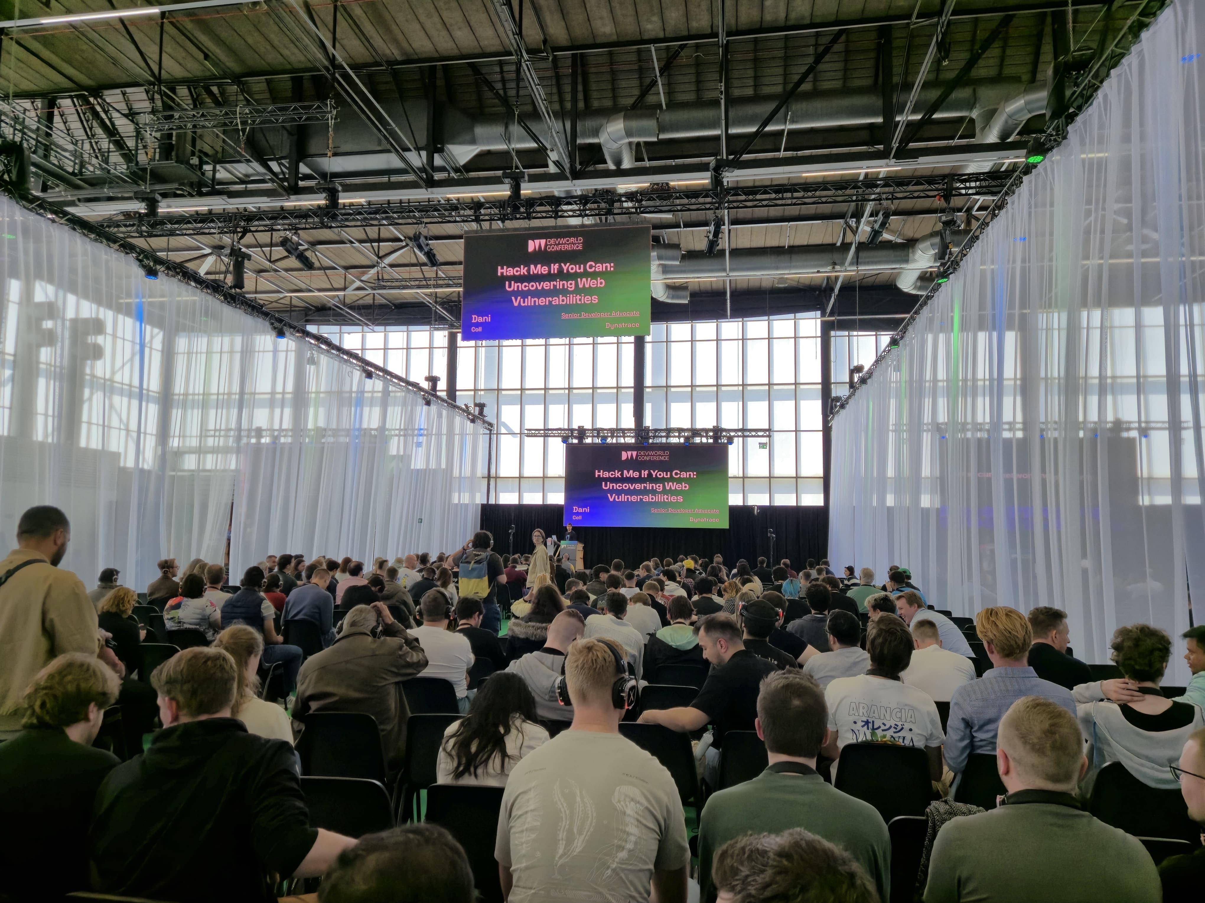 "Hack Me If You Can" title slide and packed audience at DevWorld Conference 2026